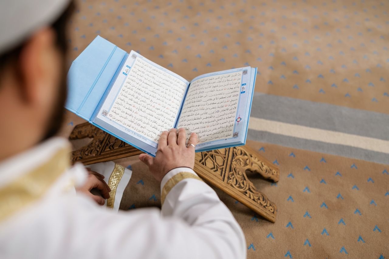 Services-01 A man reading the Quran in a mosque, focusing on spiritual connection and religious devotion.